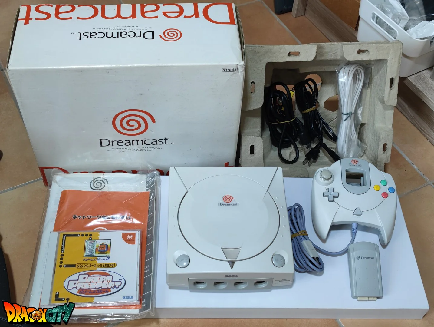 Dreamcast VA1 60Hz + Bios Freezone + Patch 50Hz/60Hz Auto + Boßte + Alimentation 220V + 1 Manette + Notices + Dream Passport 2 "NEUF" + Cùble Vidéo + Cùble Alimentation + Serial Matching + Cùble RJ11 + Jump Pack + Condensateurs GDROM "NEUF"